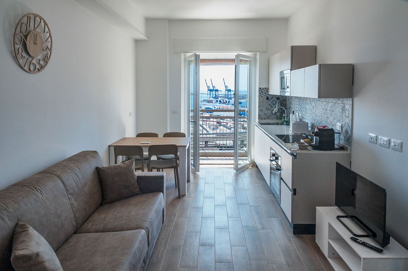 Soggiorno con divano letto e balcone vista porto